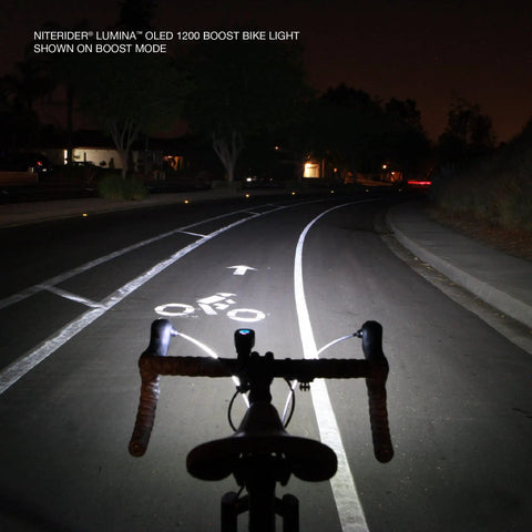 Lumina OLED Beast Mode Boost 1200 Bike Light illuminates dark road in boost mode, showing wide bike lane ahead at night