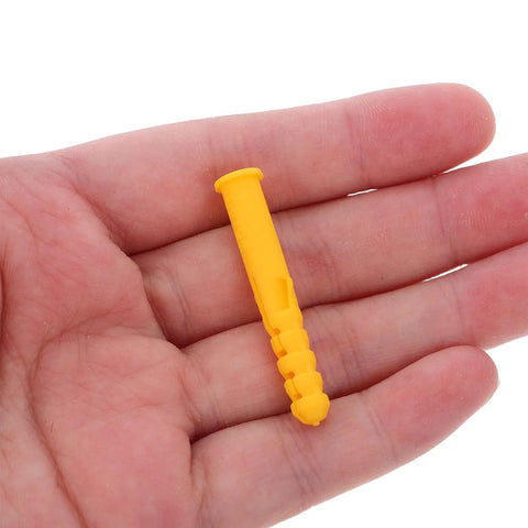 Hand holding a yellow self drilling ribbed wall plug from 200 Pack Yellow Self Drilling Ribbed Wall Plugs Set for Drywall and Hollow Walls