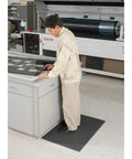 Person standing on Air Step Anti Fatigue Floor Mat Black 36 Inch Long 24 Inch Wide With Three Eighths Inch Vinyl Foam Cushioned Support
