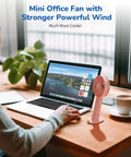 Handheld Portable Fan With 4000mAh Rechargeable Battery And 10 Hour Battery Life on a desk beside a laptop