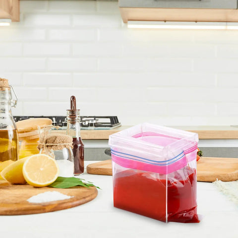 2 Pack Acrylic Food Prep Bag Holder Stand on kitchen counter holding a bag with red sauce.