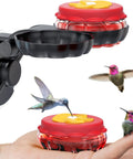 Set Of 2 Mini Glass Hummingbird Feeders With Window Mount Base For Handheld Or Tabletop Use Outdoors Holds 1 Oz Red And Yellow Flower Attractors For Grab And Go Bird Watching And Quick Feeding, showing two feeders and hummingbirds.