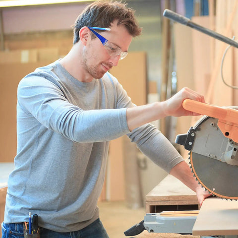Heavy Duty Safety Glasses Bulk Pack With Clear Lenses And Durable Blue Frames Engineered For The Daily Grind No Nonsense Eye Guard Gear For Job Sites Labs And Working Crews worn by worker using saw.