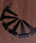 Heavy Duty Iron Black T Shape Door Hinges Set 24 Pieces 4 Inch Gate Hinges With Six Screw Holes displayed on wooden surface