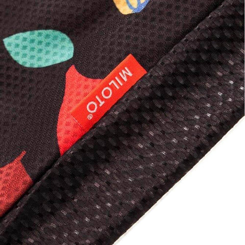 Close-up of black textured fabric with red tag labeled MILOTO and colorful design elements.