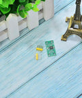 Top view of X9C103S Digital Potentiometer Module For Arduino Four Piece Set with components on wooden table near model Eiffel Tower.