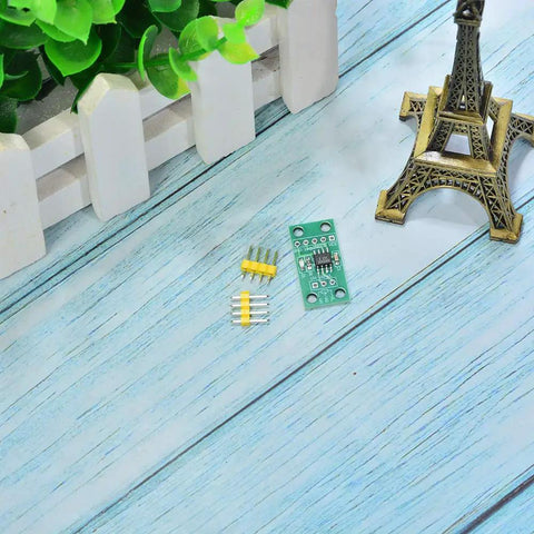 Top view of X9C103S Digital Potentiometer Module For Arduino Four Piece Set with components on wooden table near model Eiffel Tower.