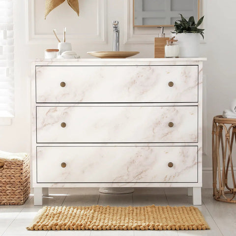 Dresser with slick marble peel and stick wallpaper for countertops, matte white gold finish, in a bathroom setting.