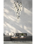 Super Sleek Modern Crystal Pendant Ceiling Light With Twenty Five Bulbs Polished Black Metal Trim Clean Design For Living Rooms And Dining Tables Hella Bright Contemporary Illumination, overhead view of hanging light fixture above a gray sofa.