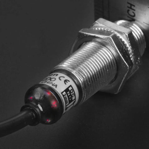 Close-up of M12 Inductive Proximity Sensor Switch PR12-2DO, cylindrical with 2mm sensing, flush mounted to a surface, CE certified.