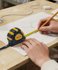 Person using tape measure on drawing for precise measurement, part of All In One 168 Piece Tool Set With Screwdrivers, Ratchet Wrenches