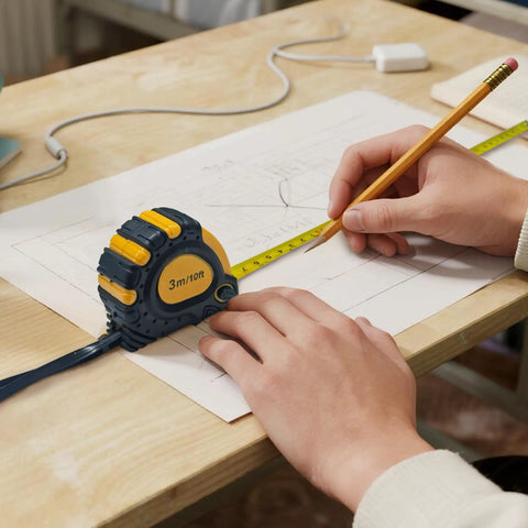 Person using tape measure on drawing for precise measurement, part of All In One 168 Piece Tool Set With Screwdrivers, Ratchet Wrenches