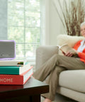 Portable Wireless Doorbell With Push Button, 350 Ft Range, 6 Tunes, 7 LED Halo Colors, 84 dB Chime on table near reader