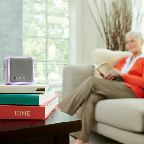Portable Wireless Doorbell With Push Button, 350 Ft Range, 6 Tunes, 7 LED Halo Colors, 84 dB Chime on table near reader