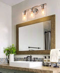 Three Light Brushed Nickel Luxe Bathroom Vanity Wall Sconce With Curved Modern Design And Clear Glass Shades Over Mirror