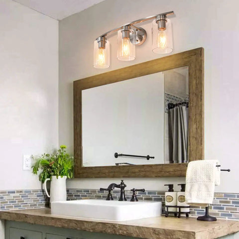 Three Light Brushed Nickel Luxe Bathroom Vanity Wall Sconce With Curved Modern Design And Clear Glass Shades Over Mirror