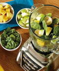 Replacement Glass Blender Jar For 6 Cup Blenders, 1.25 Liter Capacity with fruit and spinach on a blender base.