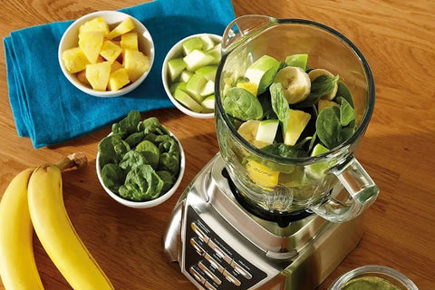 Replacement Glass Blender Jar For 6 Cup Blenders, 1.25 Liter Capacity with fruit and spinach on a blender base.