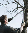 Man using Heavy Duty Bypass Loppers For Tree Trimming With German Stainless Steel Blades Rust Resistant And Beast Mode Sharp Up To 2 Inch Branches Yard Work Ready Pruner For Garden Maintenance to cut a branch