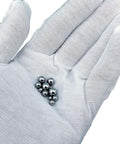 Hand holding 900 Piece Stainless Steel Precision Balls Set With Size Assortment One Quarter Inch Seven Thirty Seconds Inch