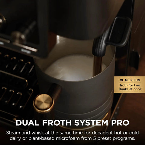 Top Shelf All In One Espresso Machine Featuring Built In Grinder And Hands Free Frother For Crisp Cold Brew And Fresh Drip Coffee Big Time Black Gold Edition frothing milk in a large jug.