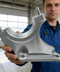 Mechanic holding a right-side CV axle shaft carrier bearing bracket direct fit replacement for 2013-2016 Escape and 2013-2017 Fusion.