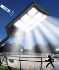 Outdoor Solar Street Light With Motion Sensor And Remote illuminating a fenced area at night, IP67 waterproof flood light for security.