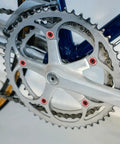 Close-up of a bicycle crankset with 10 Piece M8 Aluminum Alloy Double Chain Ring Bolts Set in red against a silver chainring.