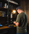 Man using bench top powder measure with improved funnel shape and static free aluminum body for accurate ammunition reloading