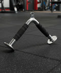 Triceps Training Bar For Cable Pulldown And Pressdown with rubber grip, steel build, on gym floor.