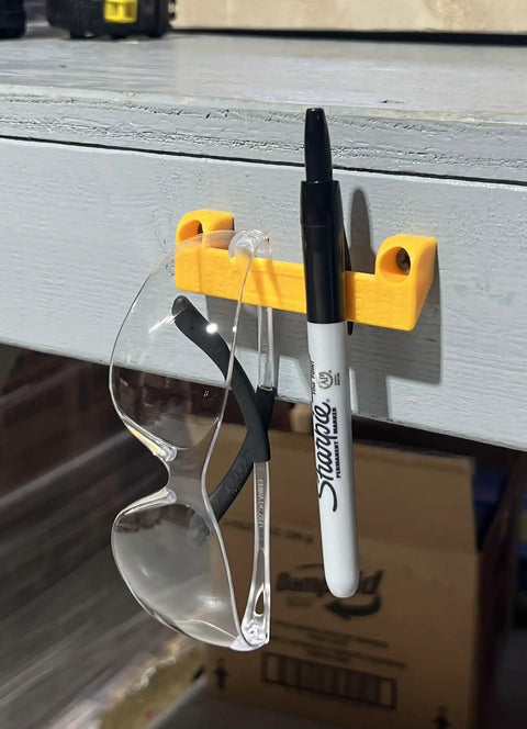 Yellow Rugged Tape Measure Holder For Garage Organization, Keeps Tools Handy On Ladder Or Workbench, Grab-And-Go Quick Install Tool Hook Pack Of 4, holding a marker and glasses on workbench.