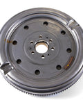 Built Tough Replacement Clutch Flywheel Drop In Install For 2004 To 2006 Volkswagen Beetle and Jetta Cars With Four Cylinder 1.9 Liter Engine Guaranteeing Slick Shifting And Zero Drama Fixes, metallic flywheel with center gear and holes.
