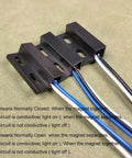 Close-up of Three Sets NO NC Black Magnetic Door Sensor Reed Switch Kit with visible cables on green surface