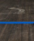Blue painter's tape strip, 0.94 inch wide, placed on dark wooden surface