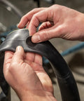Applying tire patch from Deluxe Bike Tube Repair Kit With Tire Patches, Levers, Scuffer And Tools on a bicycle tube.