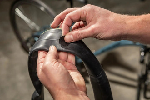 Applying tire patch from Deluxe Bike Tube Repair Kit With Tire Patches, Levers, Scuffer And Tools on a bicycle tube.