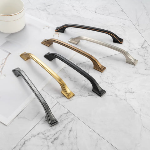 Five Pack 3 Inch Oil Rubbed Bronze Cabinet Pulls alongside different colored metal pulls on a marble surface.