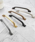 Assorted metal kitchen cabinet pulls on marble surface, including 20 Pack 3 Inch Matte Black Kitchen Cabinet Pulls No Fuss Easy Install