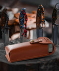 Portable Whetstone Knife Sharpener with Dual Grit 400/1000 kit in cowhide pouch beside hunting knives on wood surface