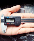 Person holding Digital Vernier Caliper 50mm 2In High Precision Measuring Tool with dual unit conversion on palm.