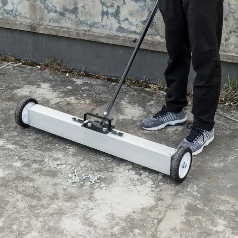 Heavy Duty 24 Inch Rolling Magnetic Pickup Sweeper With Adjustable Handle collecting nails and screws on concrete surface.