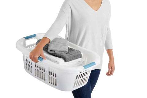 Person carrying Hip Hugger Laundry Basket With Easy One Hand Carry Grip One And A Half Bushel White Hamper Lightweight Stackable Organizer