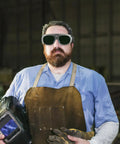 Heavy Duty Pair Of Welding Goggles With Double Layer Plastic Lens on a worker in a shop, wearing safety gear and gloves.