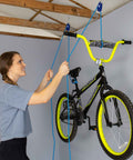 One Quarter Inch Medium Duty Tie Down System With Fifteen Foot Rope Weather Resistant 150 Lbs Working Load Jam Cleat Tension Tool used to hoist a bicycle in a garage.