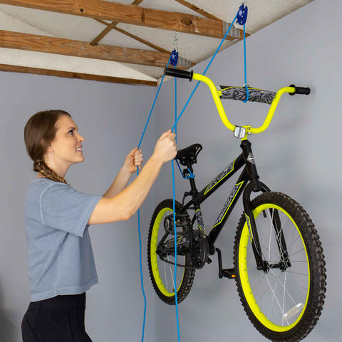 One Quarter Inch Medium Duty Tie Down System With Fifteen Foot Rope Weather Resistant 150 Lbs Working Load Jam Cleat Tension Tool used to hoist a bicycle in a garage.