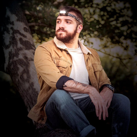 Man wearing Rechargeable USB LED Headlamp with Dual 3W LEDs, water resistant build, adjustable comfort strap, in outdoor setting.