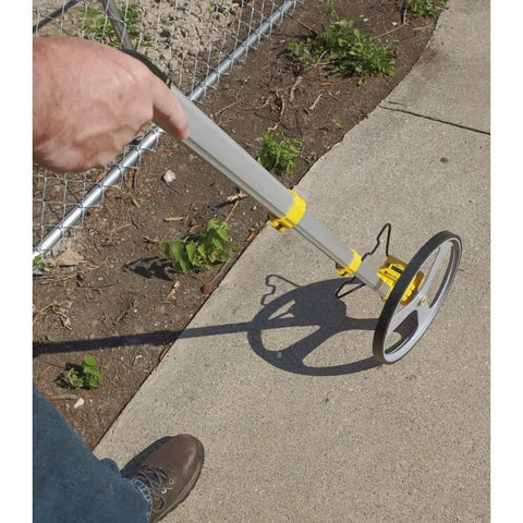 Rolatape RT312 12.5 Inch Aluminum Measuring Wheel Built To Last With Lightweight Durable Design For Landscaping And Construction, Ergonomic Pistol Grip, Yellow Great For Yards And Job Sites in use on sidewalk