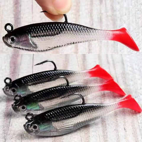 Five Piece Soft Plastic Fishing Lure Set, 8Cm T Tail Bait with 3D Eyes and sharp treble hooks on wooden surface.