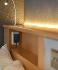 24 Watt 2 Amp LED Power Supply 110V AC To 12V DC Transformer UL Listed plugged into a wall outlet near a lit desk lamp