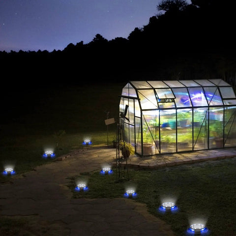 Greenhouse at night with 12 Pack Outdoor Solar Lights Waterproof Landscape Pathway Garden Lights illuminating the walkway